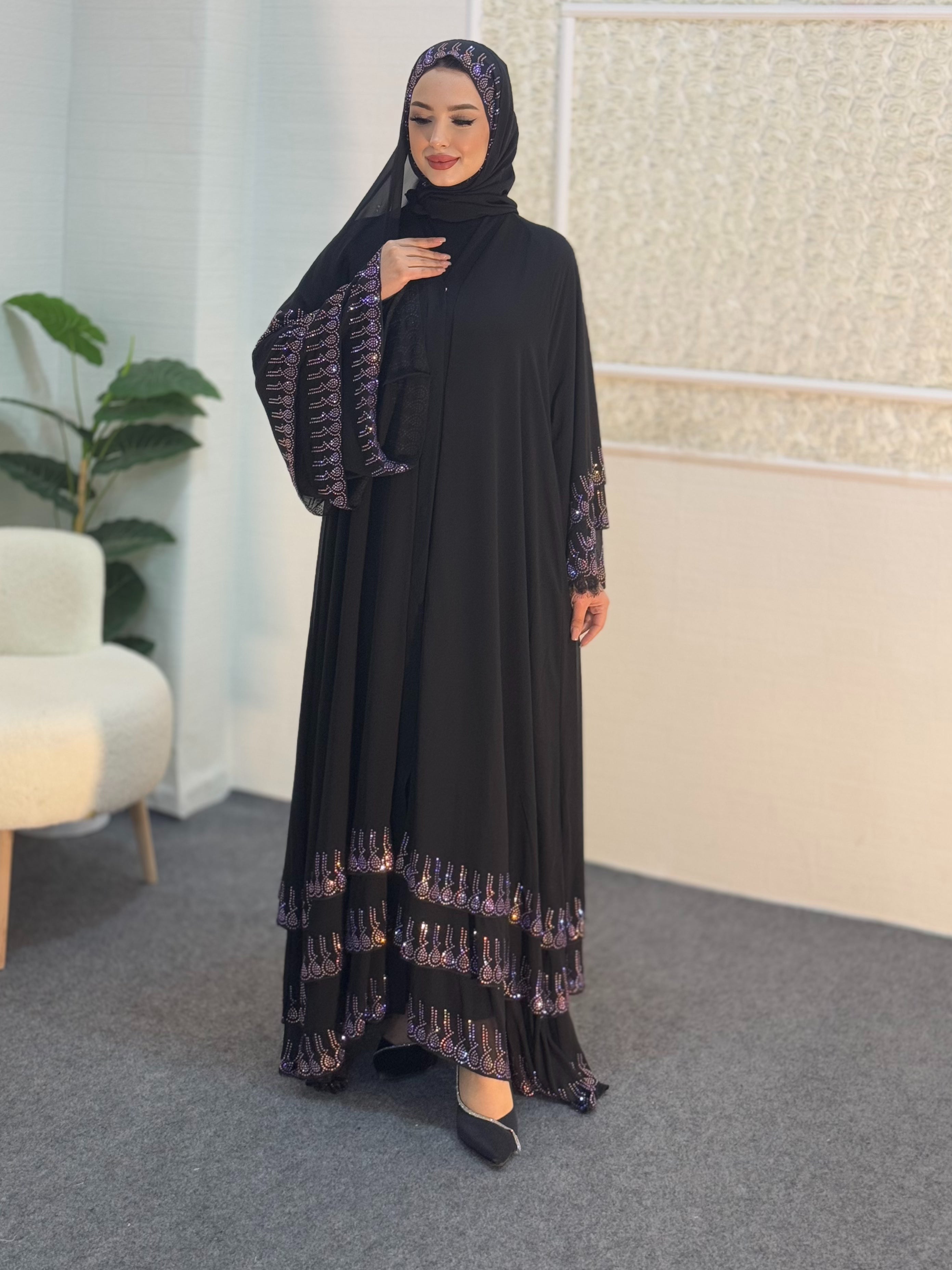 عباية سوداء مع أحجار أرجوانية على أطراف التنورة