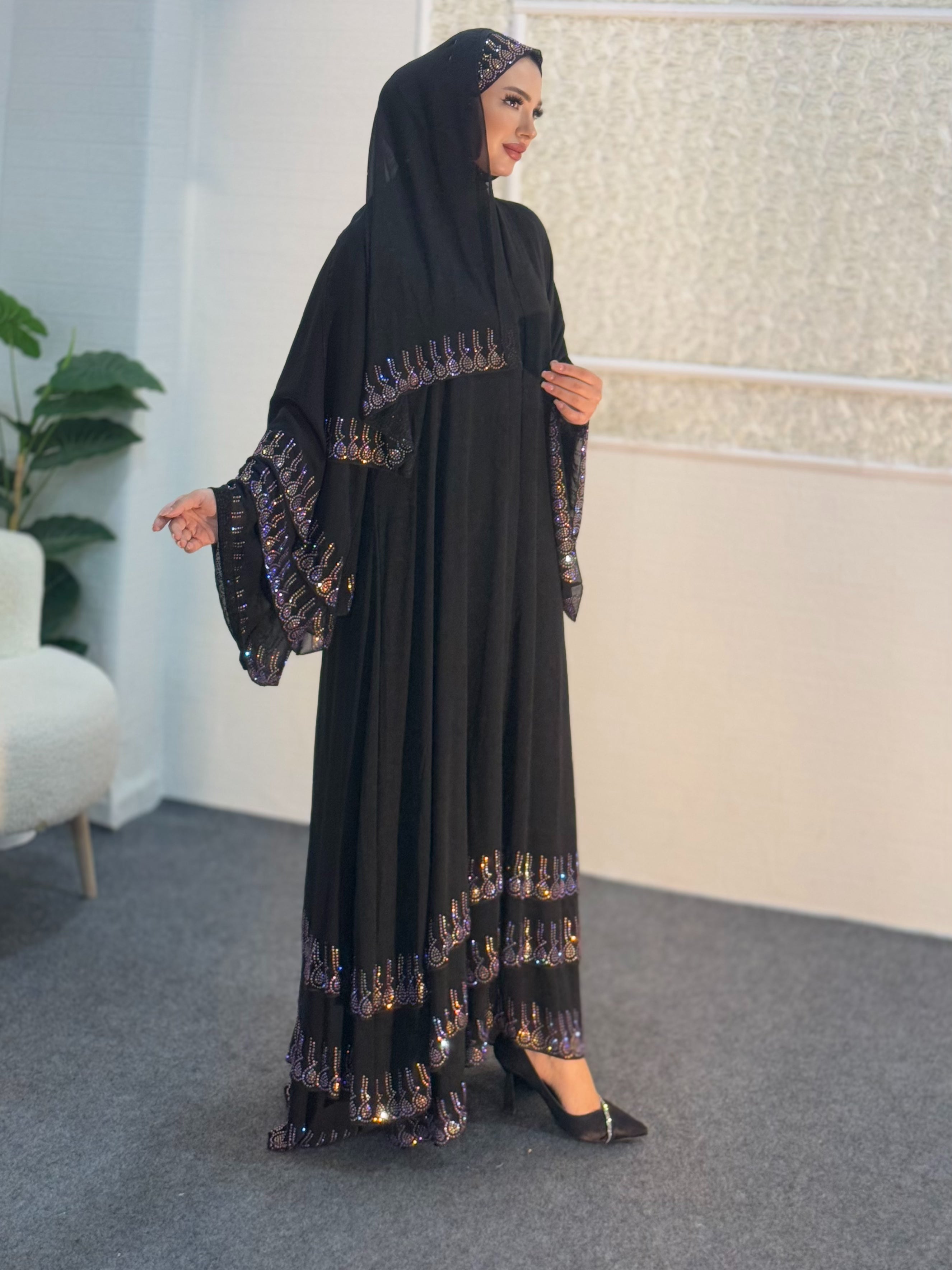 عباية سوداء مع أحجار أرجوانية على أطراف التنورة