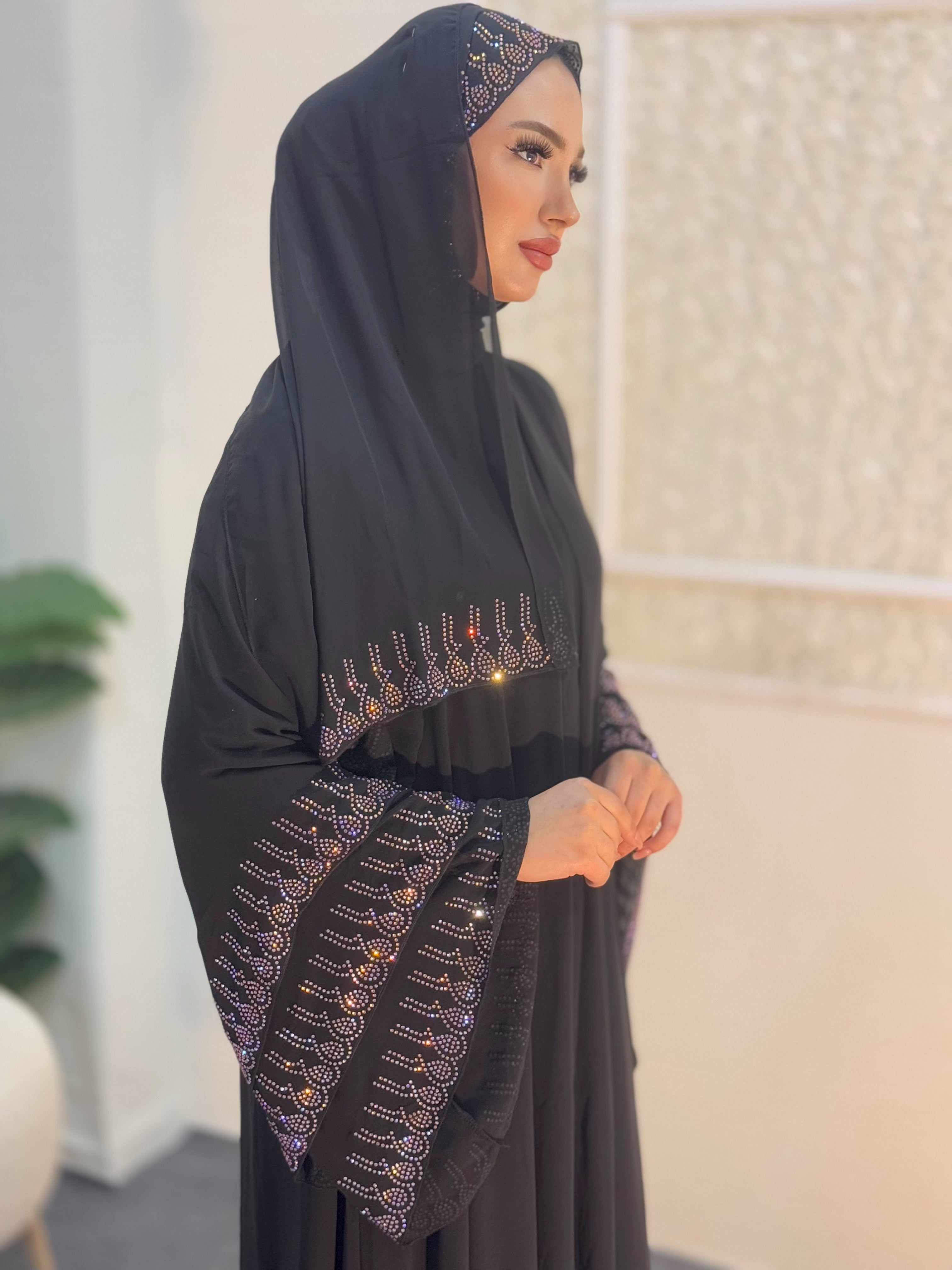 عباية سوداء مع أحجار أرجوانية على أطراف التنورة