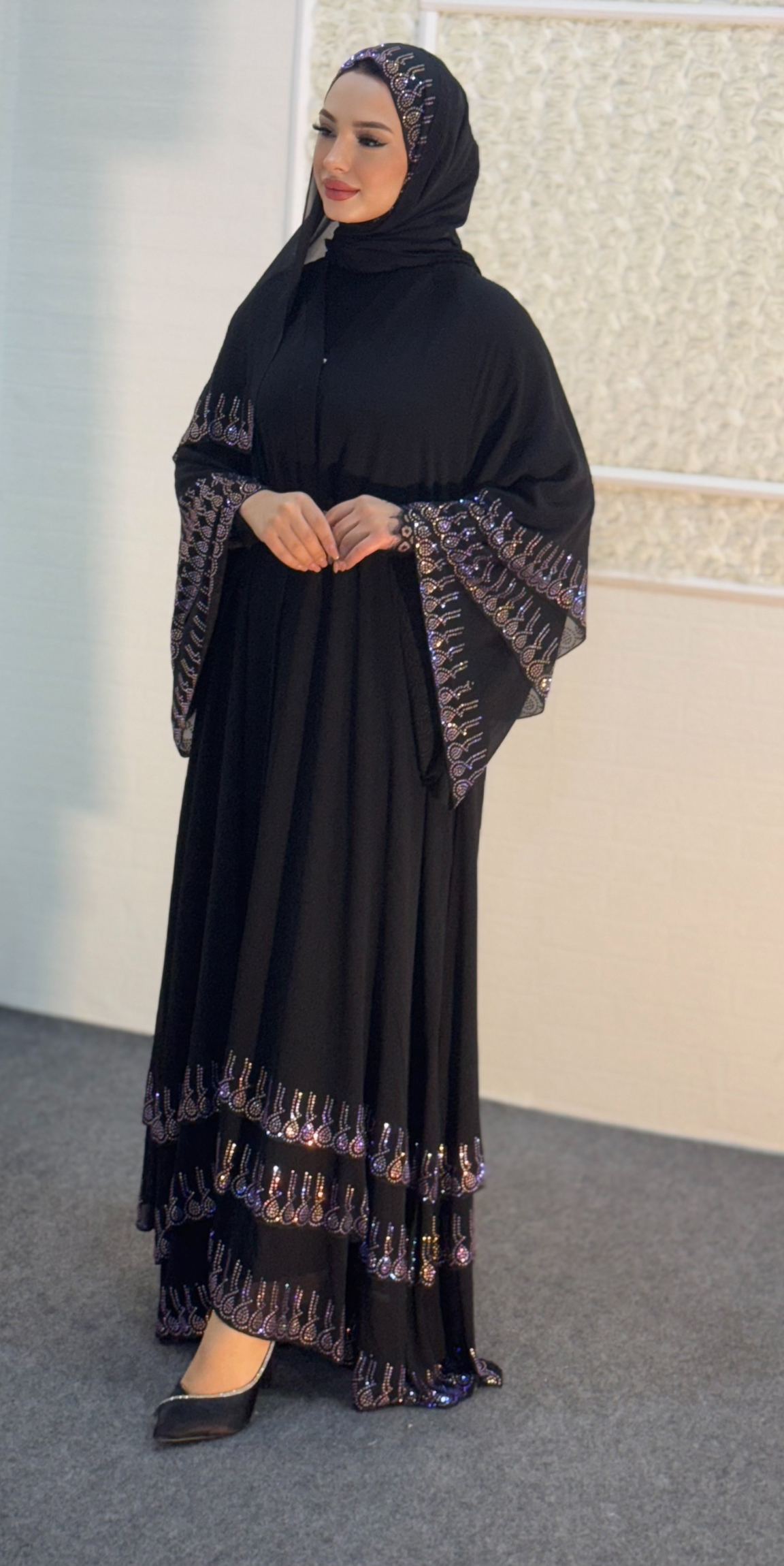 عباية سوداء مع أحجار أرجوانية على أطراف التنورة