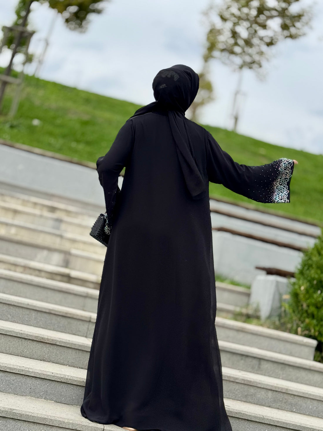 عباية سوداء بنقشة زهور سواروفسكي على أطراف التنورة