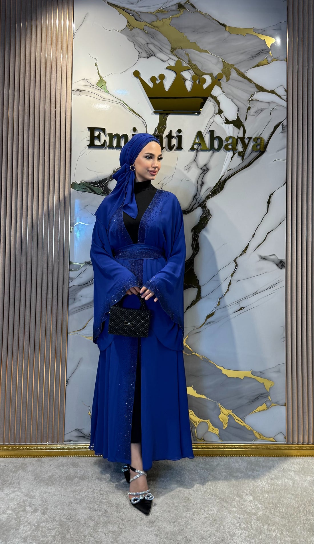 Elegant blue abaya with black stone embellishments on the front.